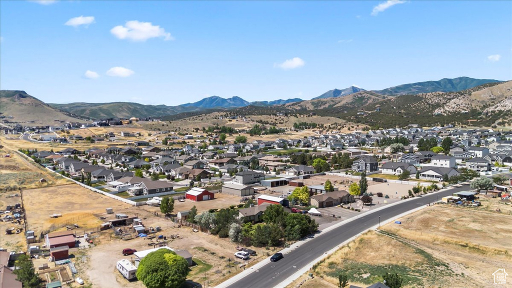 Aerial view of property's location featuring a mountain backdrop and nearby suburban area