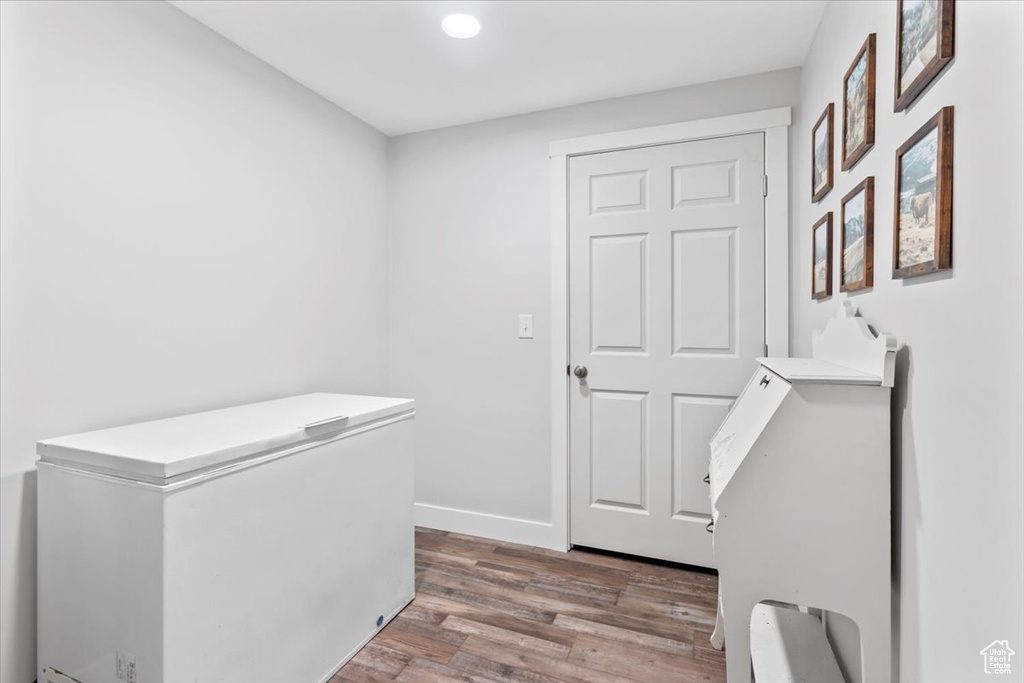Hallway with wood finished floors and recessed lighting