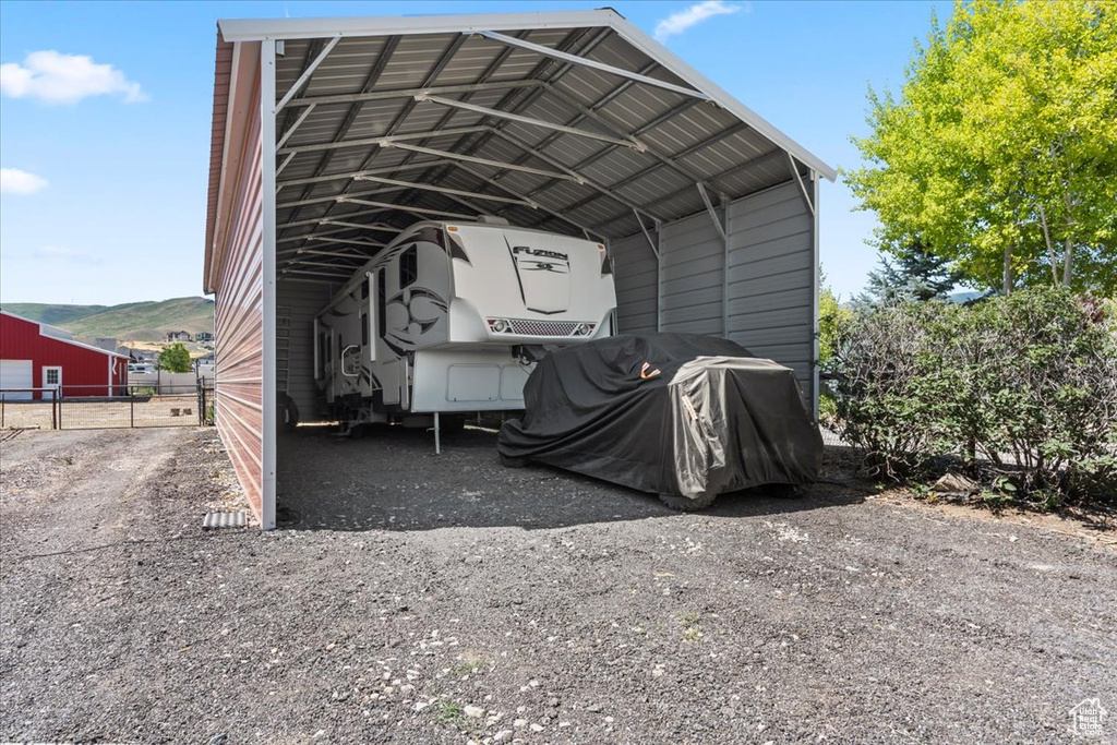 View of vehicle parking featuring a carport and gravel driveway