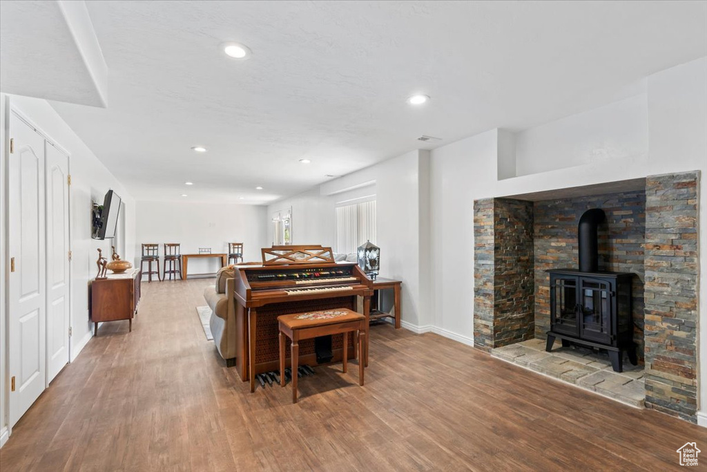 Living room featuring wood finished floors, a wood stove, and recessed lighting