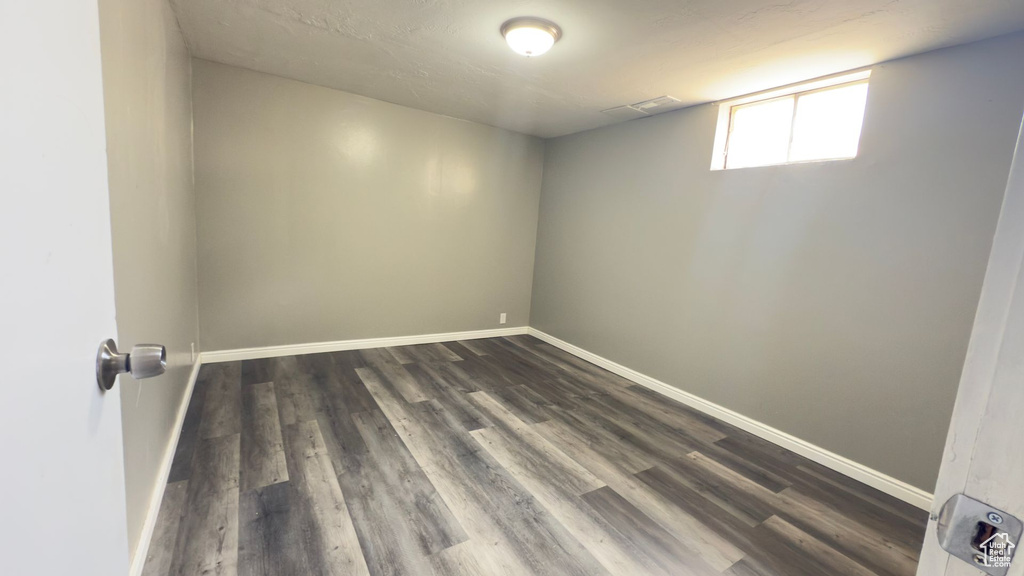 Unfurnished room featuring dark wood finished floors and baseboards