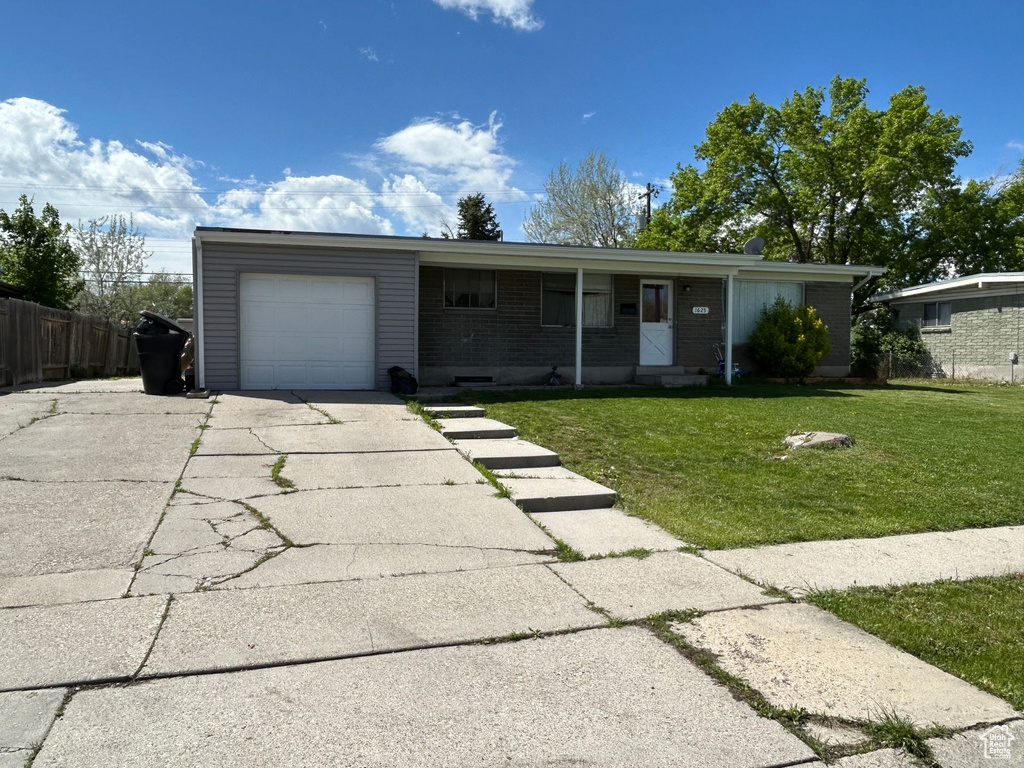Ranch-style house with a garage, driveway, and brick siding