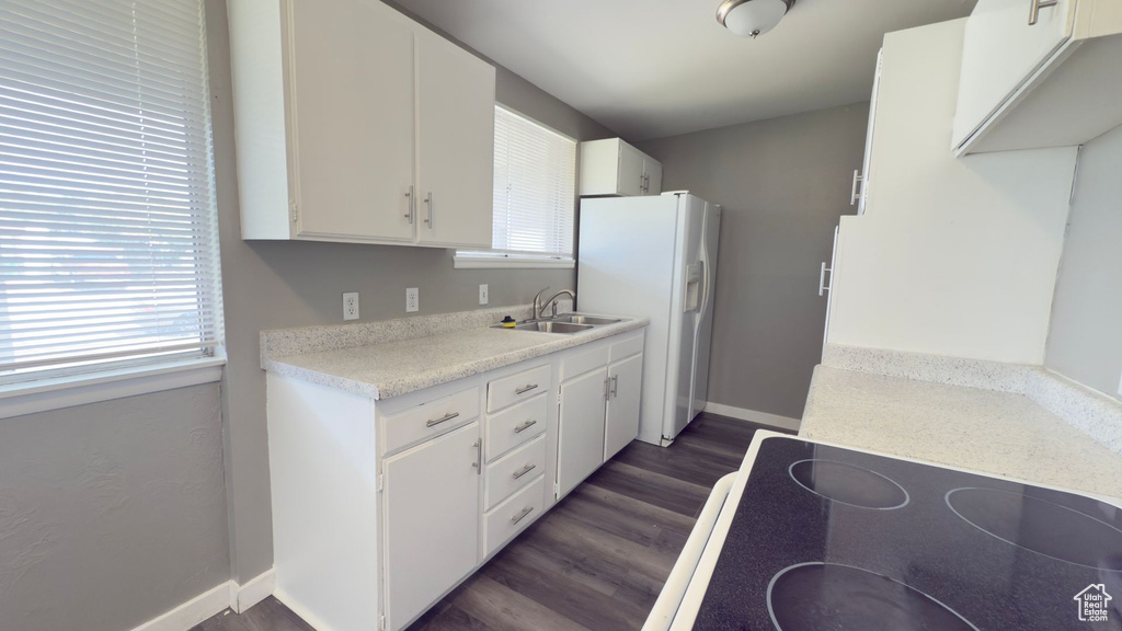 Kitchen featuring white refrigerator with ice dispenser, dark wood-style floors, healthy amount of natural light, and light countertops