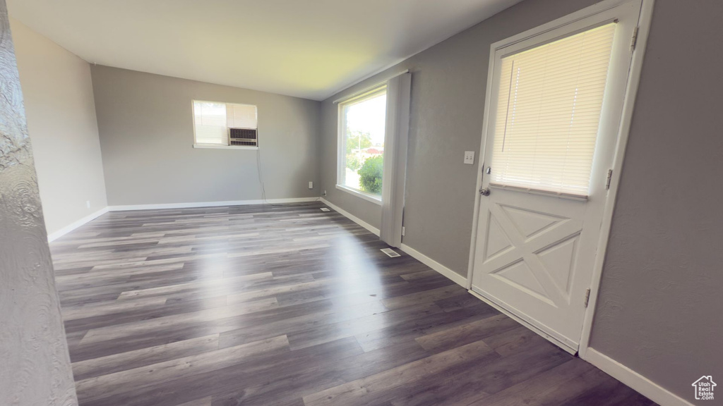 Empty room featuring dark wood-style floors and baseboards