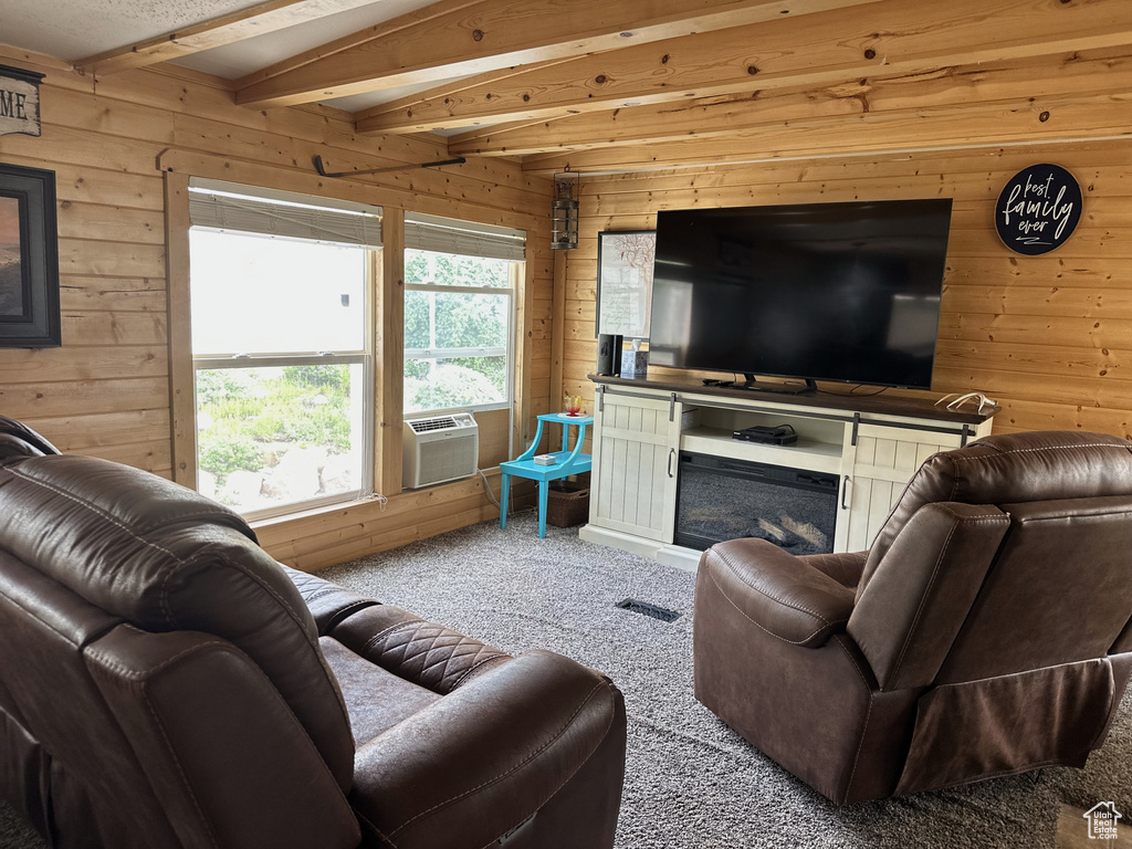 Living room with wood walls, carpet flooring, beam ceiling, and cooling unit