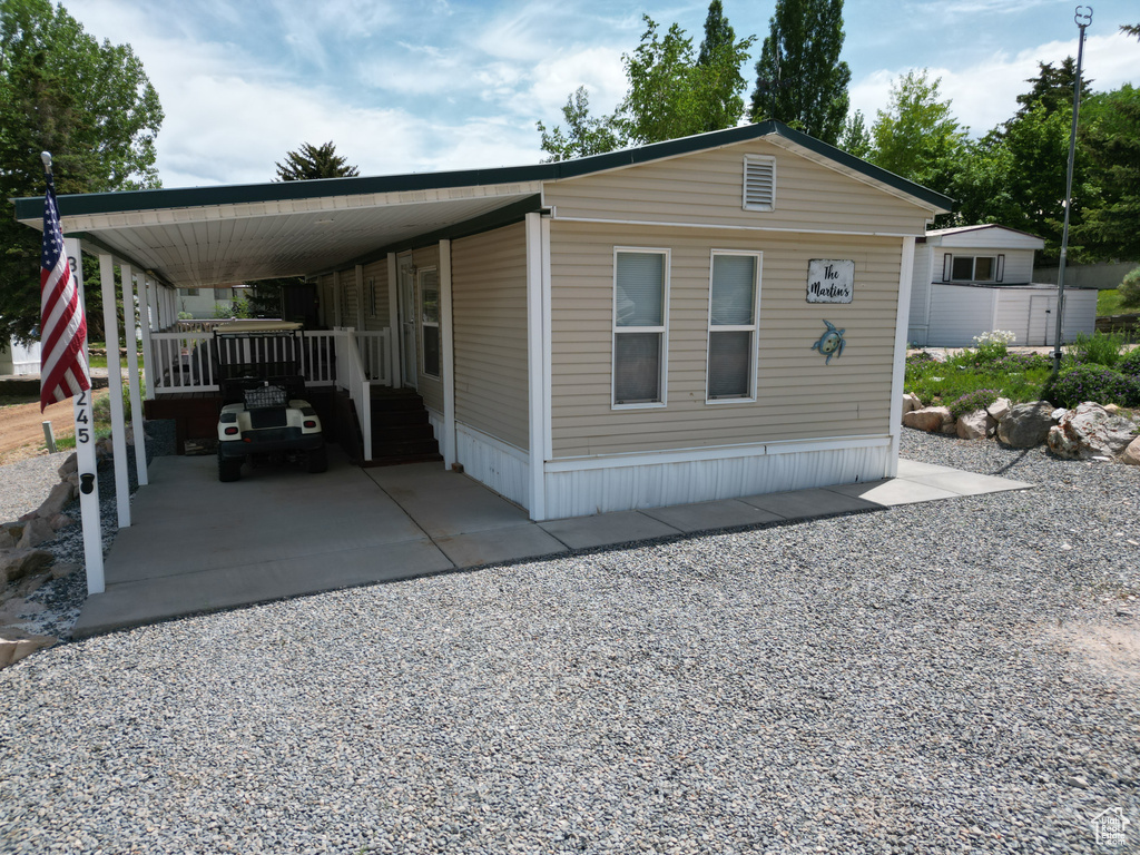 View of front of house featuring gravel driveway and a carport