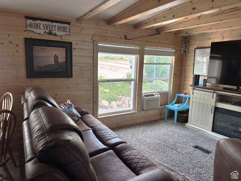Carpeted living area with wooden walls, beamed ceiling, and cooling unit