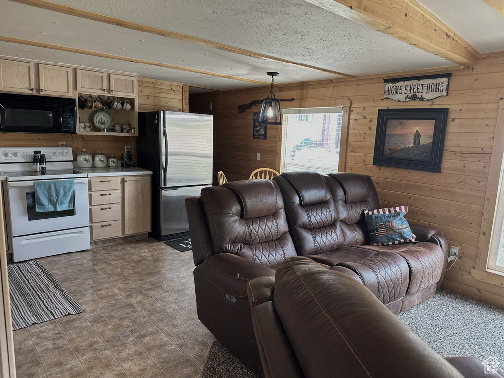 Living area with wood walls, healthy amount of natural light, and beamed ceiling