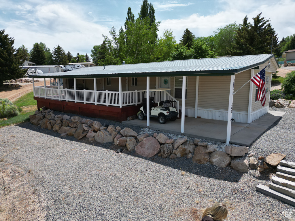 View of front of home with a metal roof and a carport