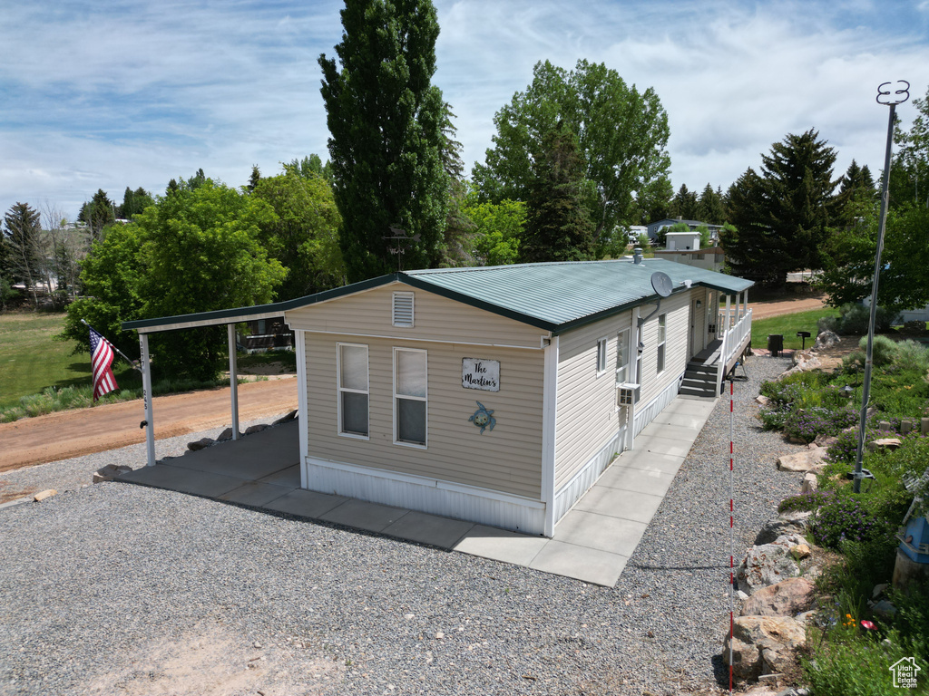 View of side of home with a metal roof and a carport