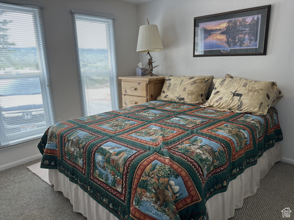 Bedroom featuring carpet and baseboards