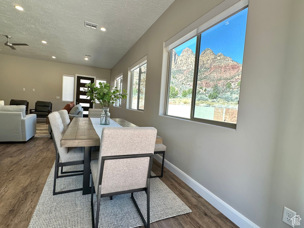 Dining space featuring wood finished floors, a textured ceiling, and recessed lighting