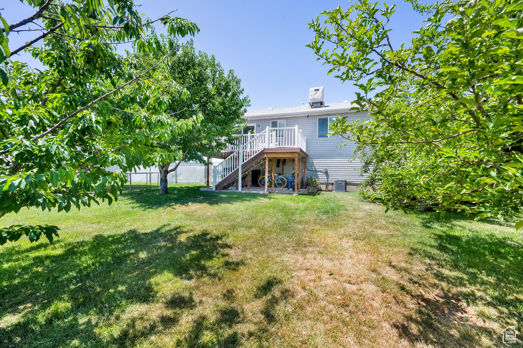 Back of property featuring stairs and a wooden deck