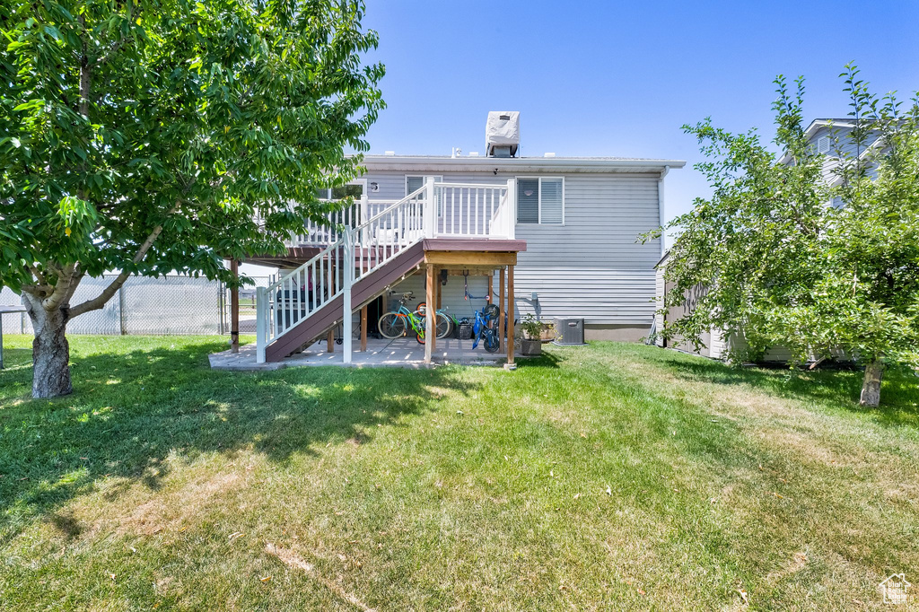 Rear view of house featuring stairway, a wooden deck, and a patio