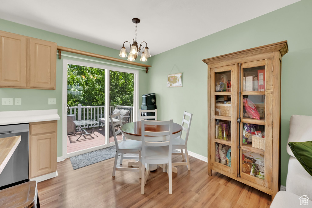 Dining space featuring light wood-type flooring and a chandelier