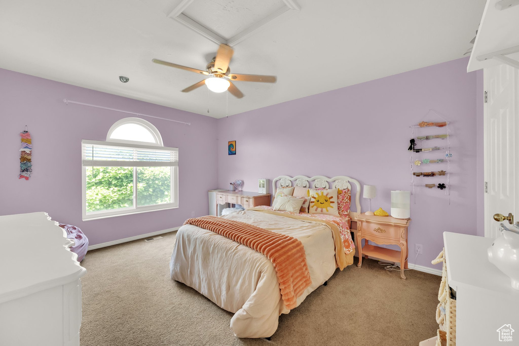 Bedroom with light carpet, attic access, and a ceiling fan
