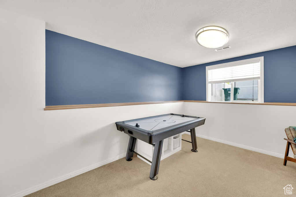 Playroom with carpet and a textured ceiling
