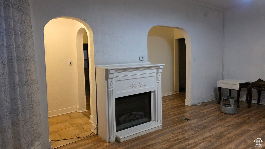 Living area featuring wood finished floors, arched walkways, and a fireplace