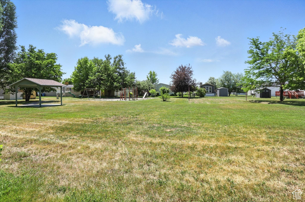 View of grassy yard with a gazebo and a storage shed