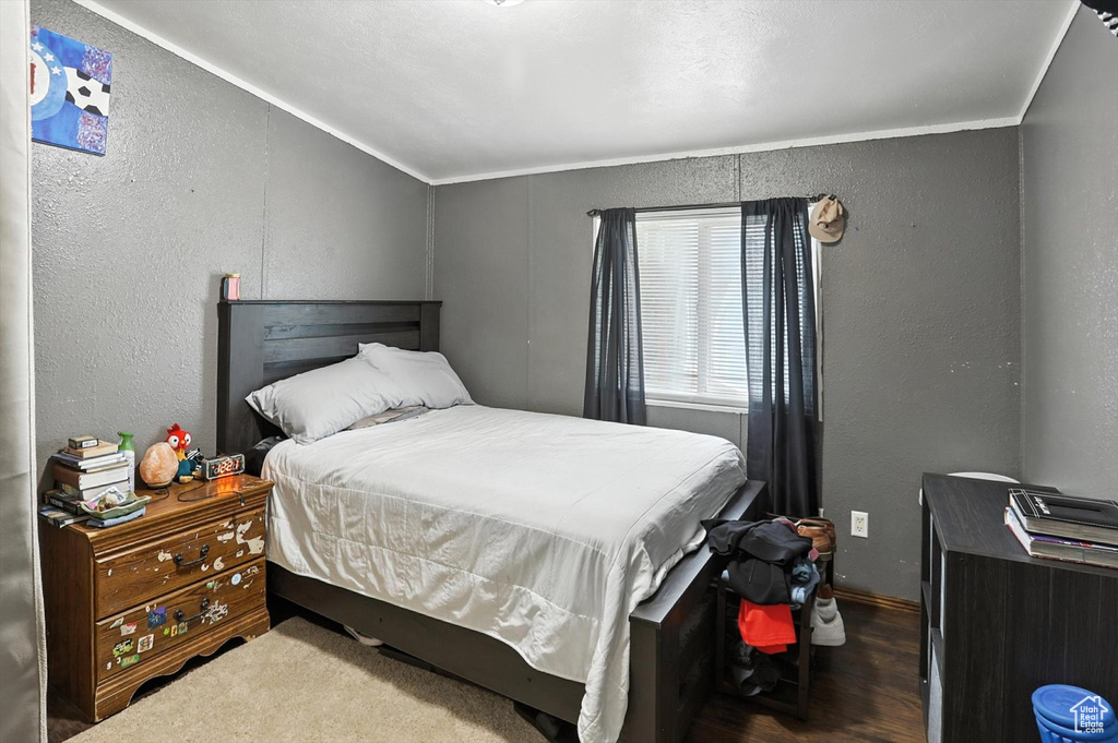 Bedroom with a textured wall and wood finished floors