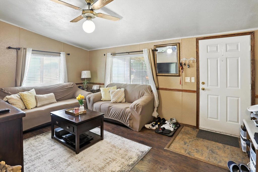 Living area featuring lofted ceiling, ceiling fan, wood finished floors, and crown molding