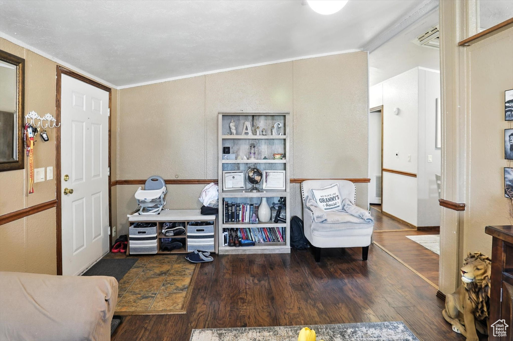 Sitting room with wood finished floors and crown molding