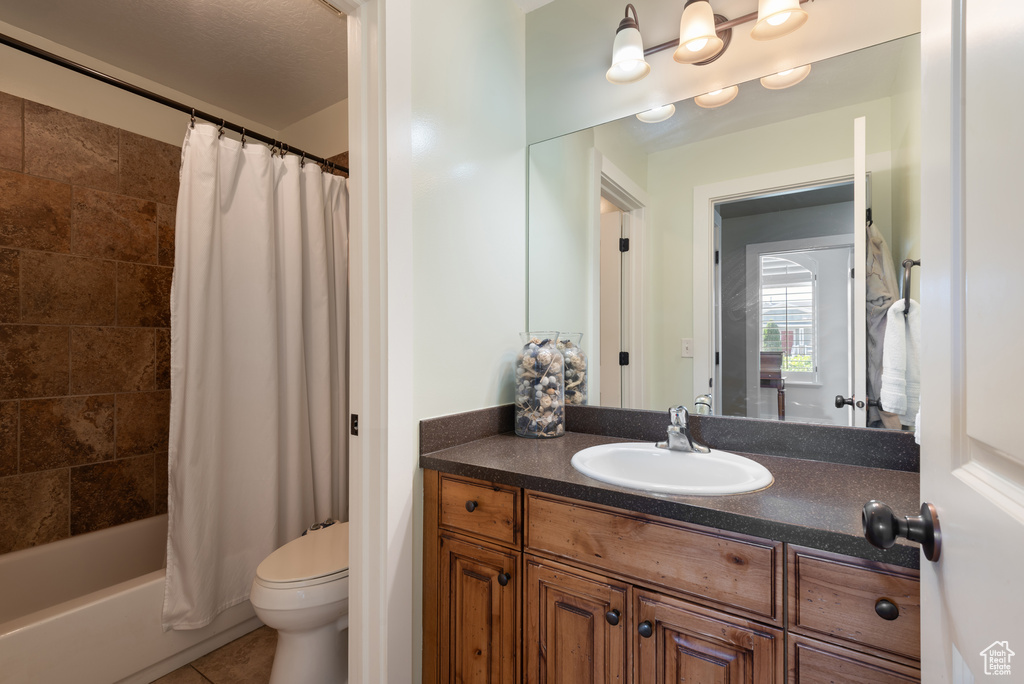 Full bathroom featuring vanity, shower / bathtub combination with curtain, and tile patterned floors