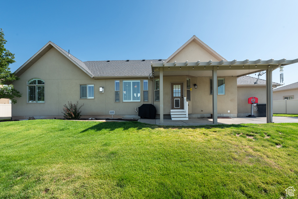 Rear view of house featuring entry steps, stucco siding, a patio area, and roof with shingles