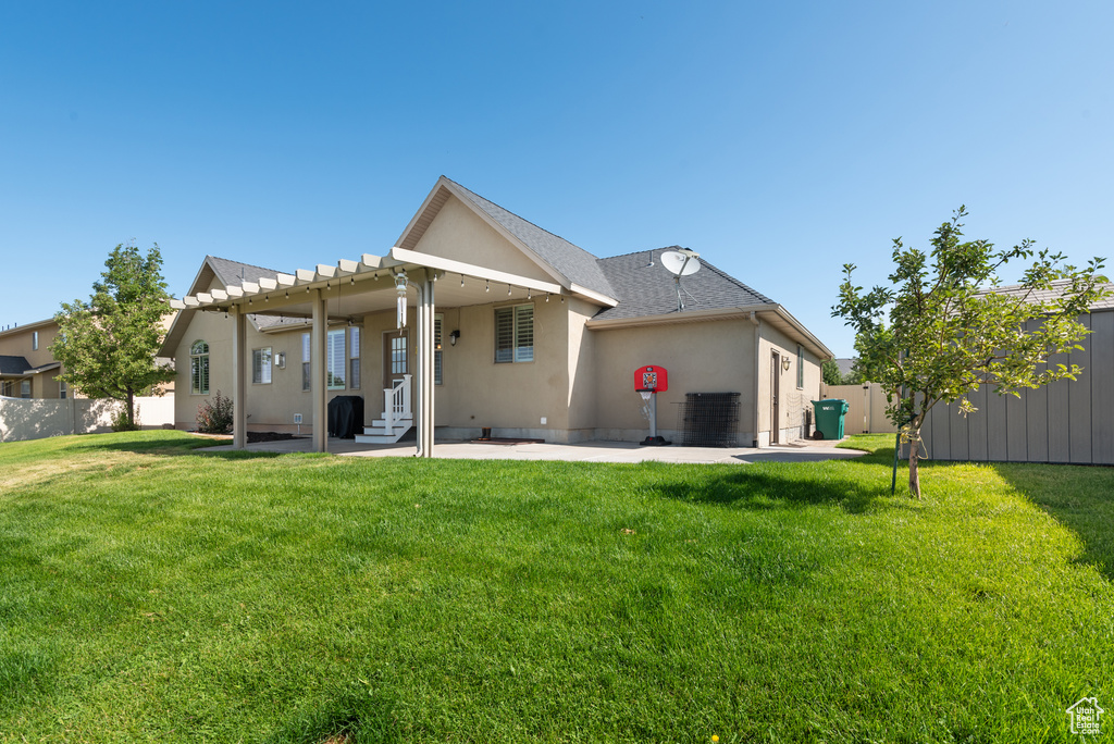 Rear view of house with a patio area and stucco siding
