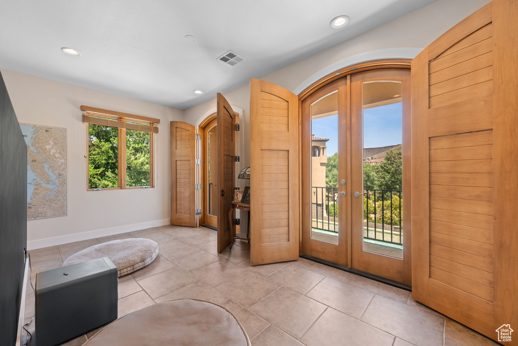 Doorway featuring french doors, recessed lighting, arched walkways, and light tile patterned floors