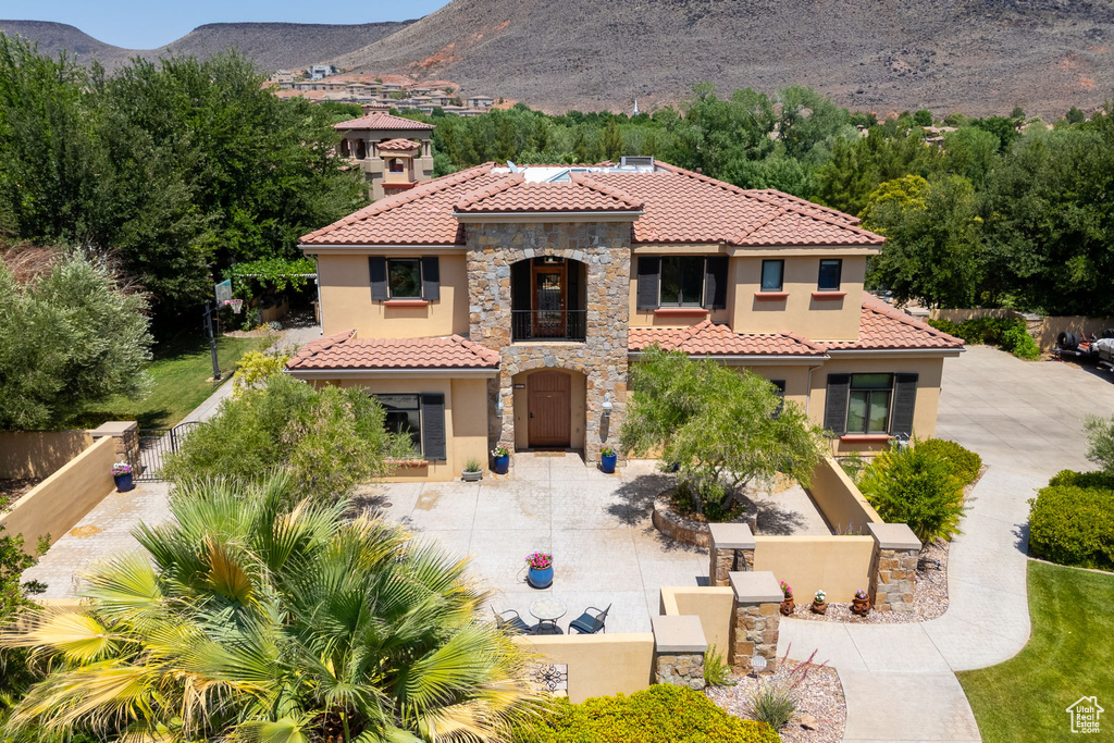 Mediterranean / spanish home with stucco siding, a balcony, a tile roof, and a mountain view