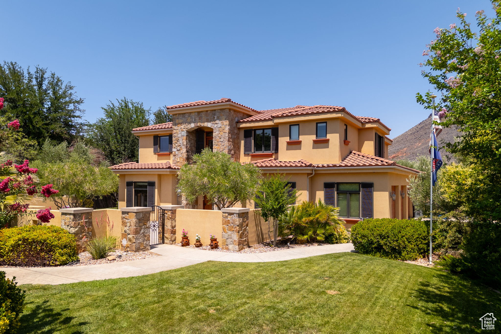 Mediterranean / spanish house featuring stone siding, stucco siding, and a tiled roof