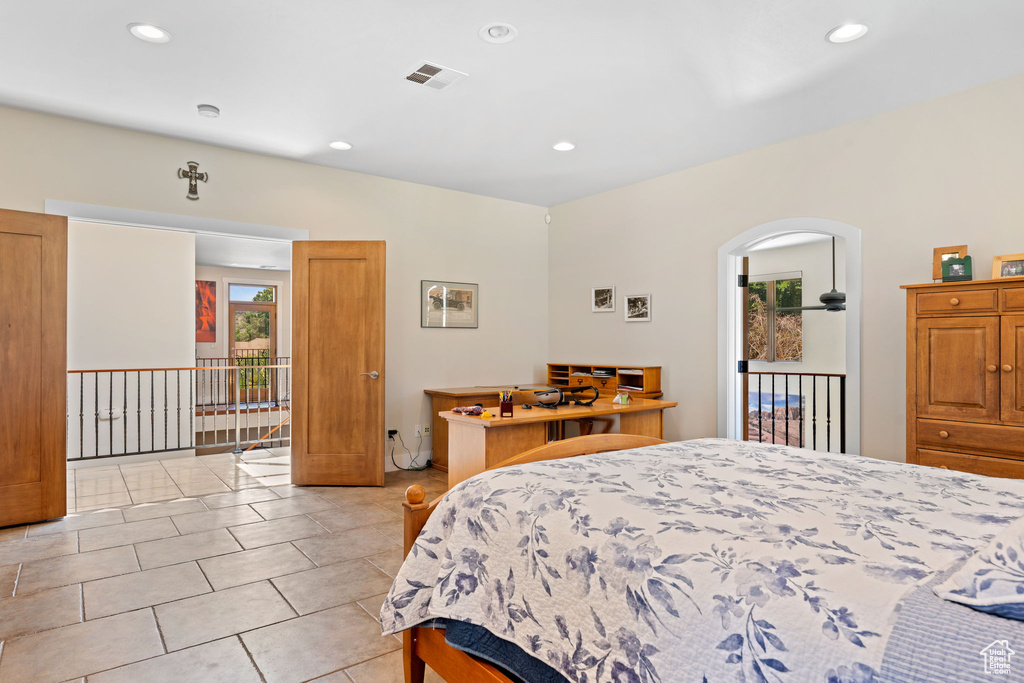 Bedroom featuring light tile patterned floors, recessed lighting, and arched walkways