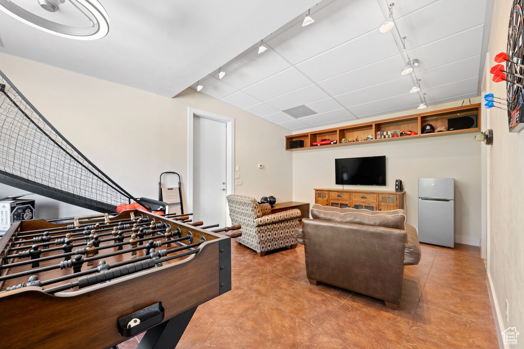 Game room featuring rail lighting and tile patterned floors