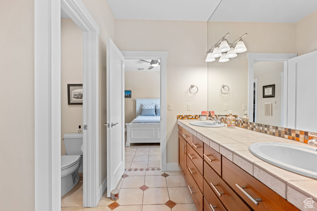 Bathroom featuring double vanity, tile patterned flooring, ensuite bath, and a ceiling fan