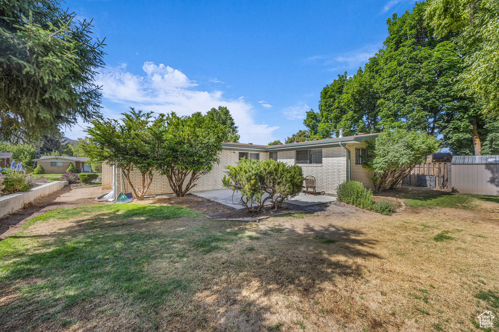 Back of property featuring brick siding and a patio