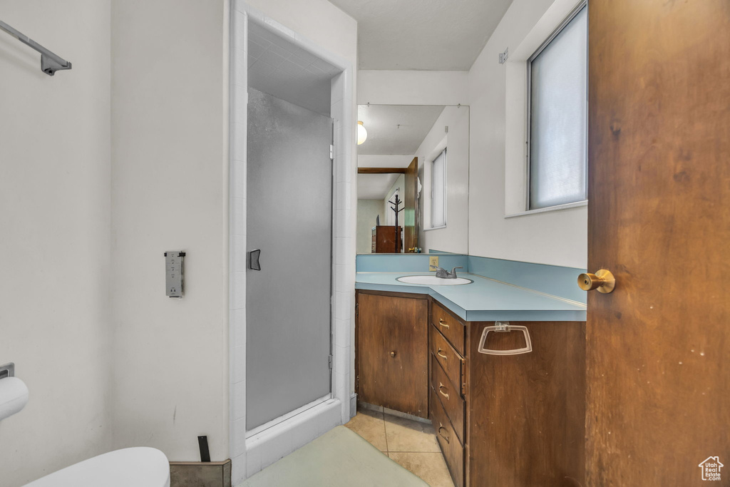Full bath with vanity, a shower stall, and tile patterned flooring
