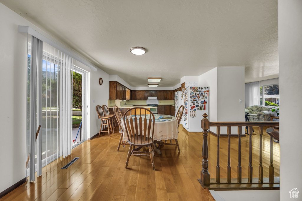 Dining space featuring light wood-style flooring and a textured ceiling
