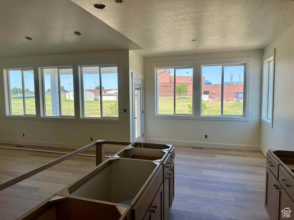 Kitchen featuring a textured ceiling, plenty of natural light, light wood-type flooring, and recessed lighting