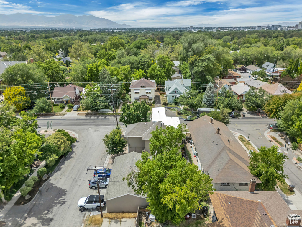 Aerial view of residential area with a heavily wooded area and mountains