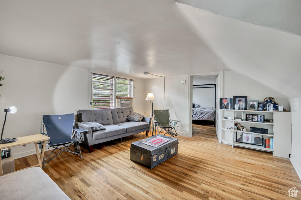 Living area with hardwood / wood-style floors and lofted ceiling