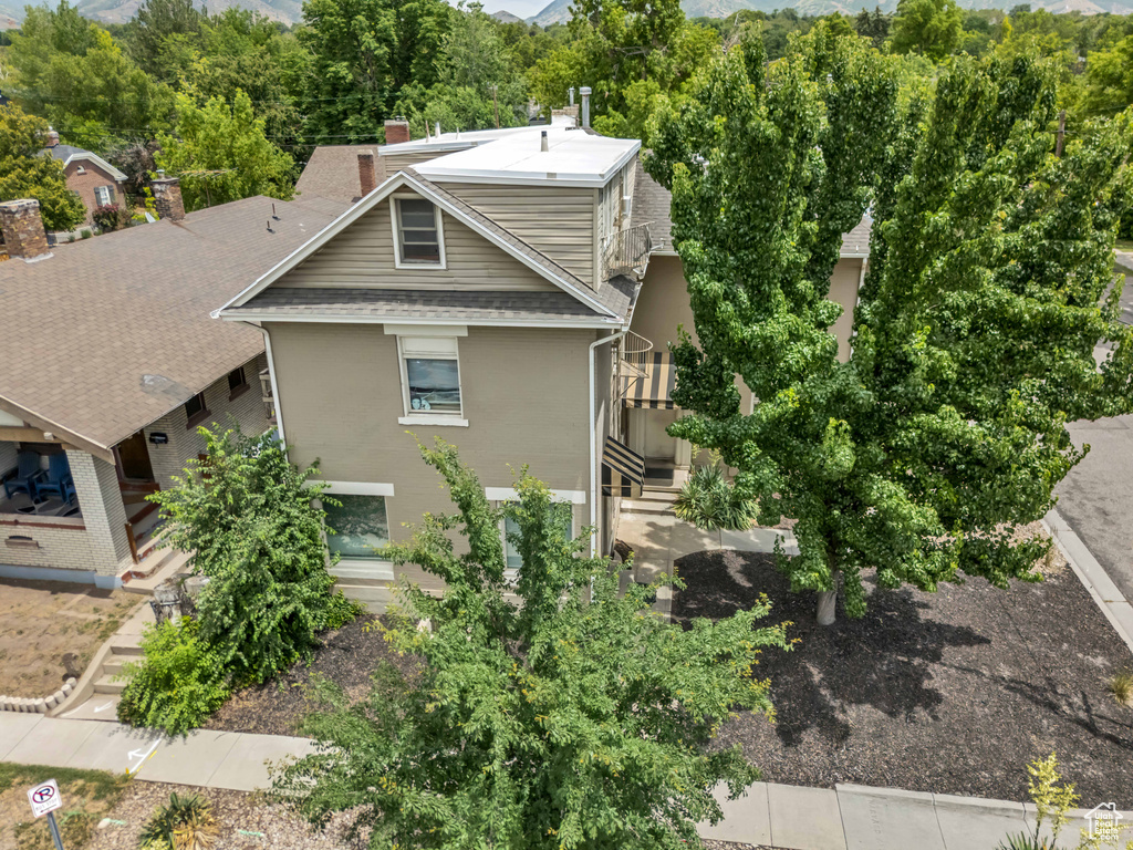 View of property exterior featuring a chimney and a shingled roof