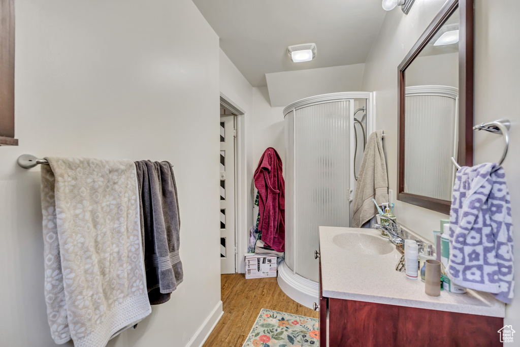 Bathroom featuring vanity, a shower stall, and wood finished floors