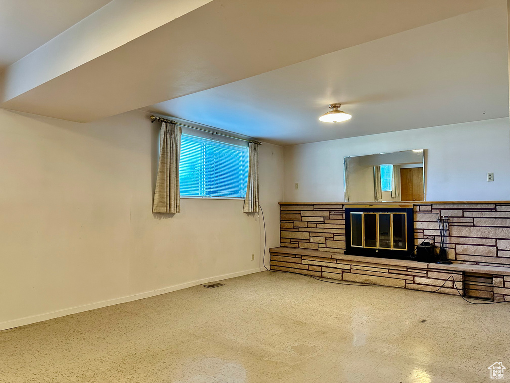 Unfurnished living room with healthy amount of natural light and a fireplace