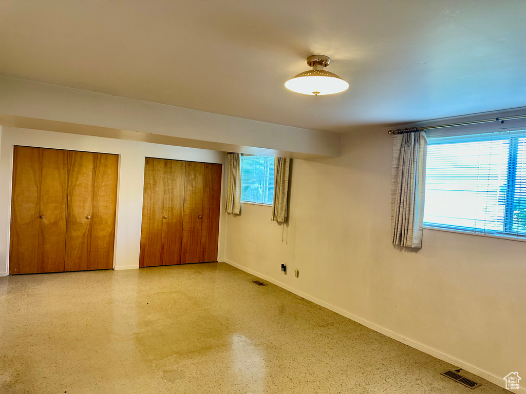 Unfurnished bedroom with baseboards and multiple closets