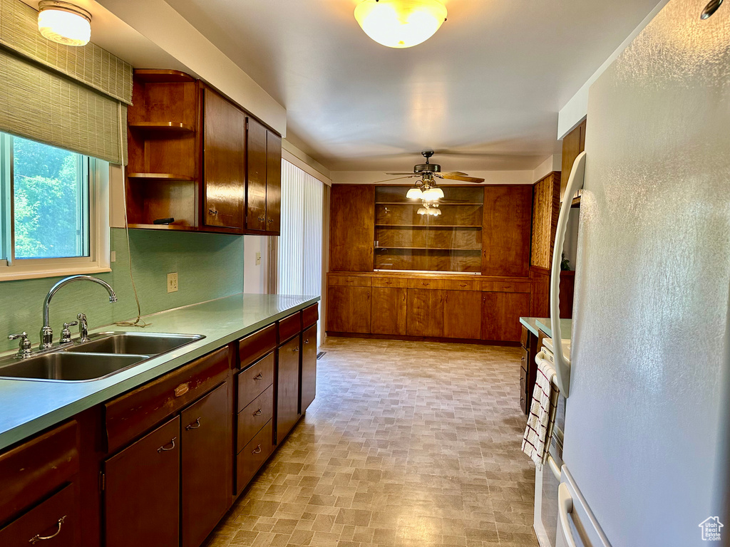 Kitchen featuring freestanding refrigerator, ceiling fan, and open shelves