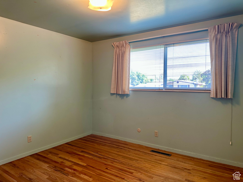 Empty room featuring wood finished floors and baseboards