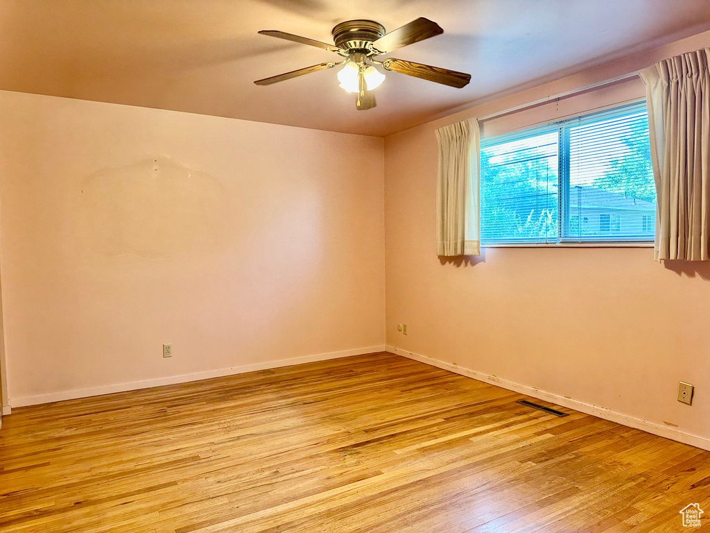 Unfurnished room featuring light wood finished floors and a ceiling fan