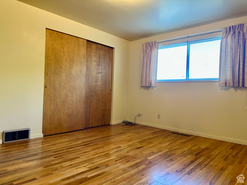 Unfurnished bedroom featuring wood finished floors and a closet
