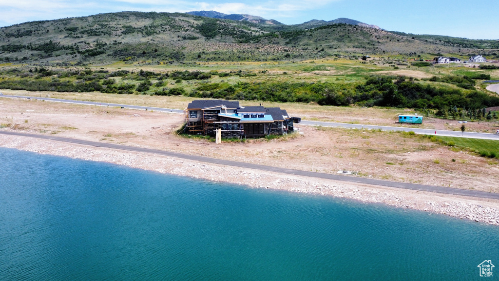 Aerial view of property and surrounding area featuring a water and mountain view